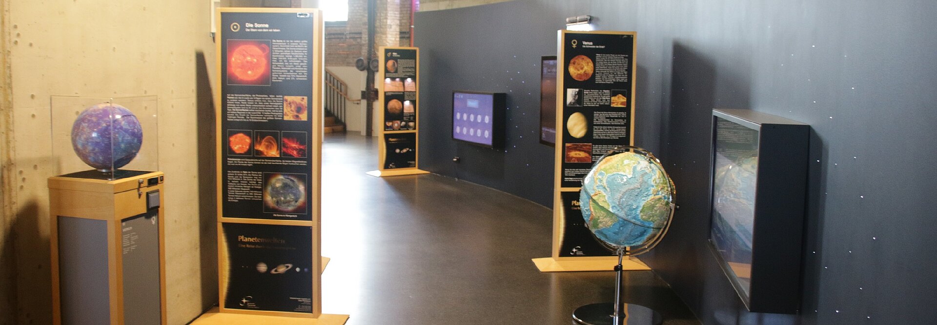 Blick in die Ausstellung im Foyer des Planetariums mit tastbarem Erdglobus und Ausstellungsstelen Header_Planetenausstellung_DS.JPG