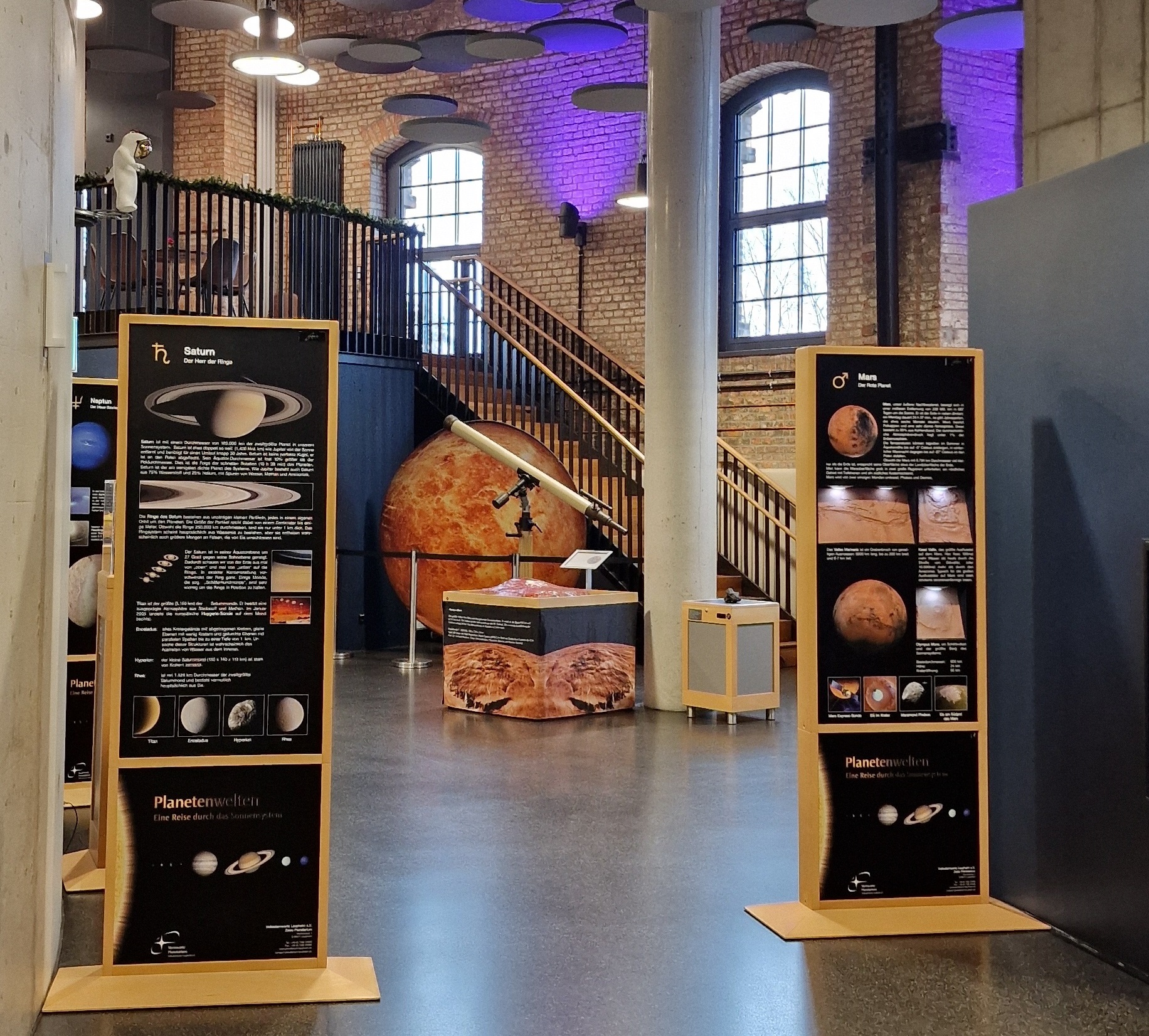 Ausstellungsstelen im Foyer des Planetarium Halle mit Olympus-Mons-Relief im Hintergrund